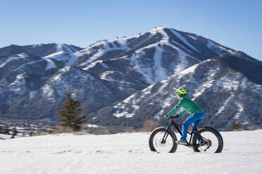 Eine Frau fährt mit ihrem Fatbike an einem schönen Wintertag im Sun Valley. - CAVF84493