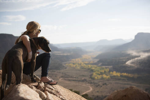 Eine Frau und ihr Hund genießen die Aussicht auf die Wüste, Utah - CAVF84502