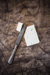 Feta-Käse und Tafelmesser auf Holzunterlage - GIOF08349