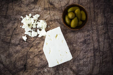 Feta-Käse und Schale mit frischen Oliven auf Holzunterlage - GIOF08351