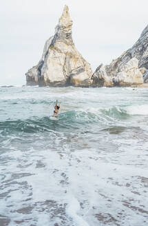 Junge Frau schwimmt im Meer gegen den Himmel, Strand Ursa, Portugal - FVSF00437