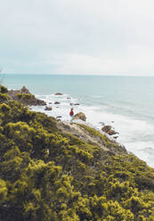 Young woman standing on mountain by sea against sky, Ursa beach, Portugal - FVSF00443