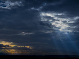 Sonnenlicht durchdringt dunkle Gewitterwolken - EJWF00909