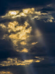 Sonnenlicht durchdringt dunkle Gewitterwolken - EJWF00911
