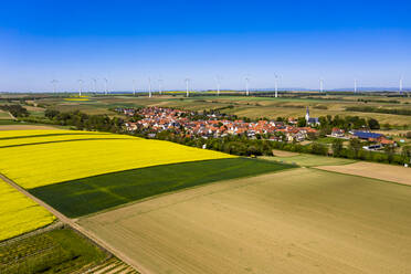 Deutschland, Rheinland-Pfalz, Gabsheim, Blick aus dem Hubschrauber auf Felder und Dorf im Sommer mit Windpark im Hintergrund - AMF08175