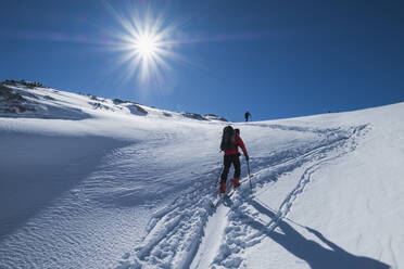 Älterer Mann beim Skifahren auf dem schneebedeckten Dachstein gegen den Himmel an einem sonnigen Tag, Österreich - HAMF00626