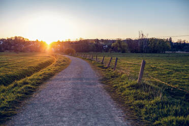 Deutschland, Bayern, Neusäß, Landschaft Feldweg bei Sonnenuntergang - MAMF01266