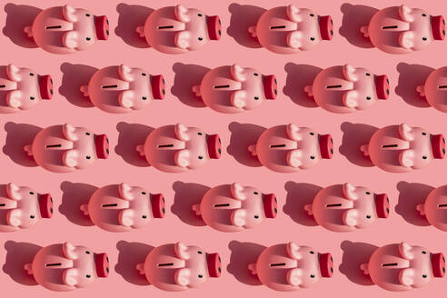 Seamless pattern of rows of piggy banks against pastel pink background - GEMF03840