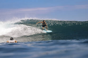 Shirtless man surfing on sea against sky, Bali, Indonesia - KNTF04668