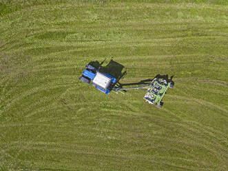 Russia, Moscow Oblast, Tractor starting to plow green field - KNTF04673