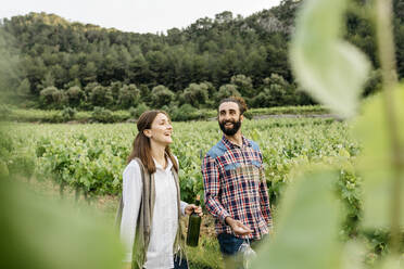 Glückliches Paar unterhält sich beim Spaziergang im Weinberg - JRFF04486