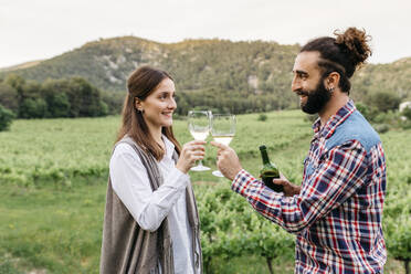 Happy couple toasting wineglasses at vineyard - JRFF04492