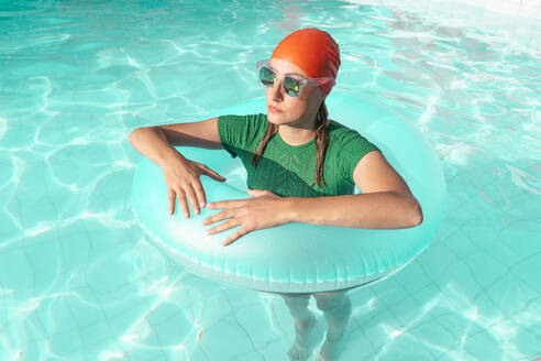 Porträt einer Frau mit Schwimmreifen im Schwimmbad - ERRF03977