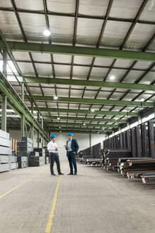 Zwei Geschäftsleute unterhalten sich in einer Fabrik - MOEF02900