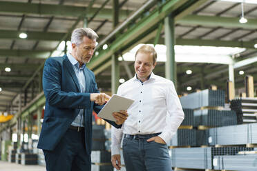 Two businessmen using tablet in a factory - MOEF02921
