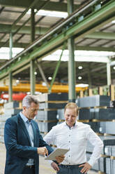 Two businessmen using tablet in a factory - MOEF02923