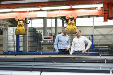 Two businessmen having a meeting in a factory - MOEF03009