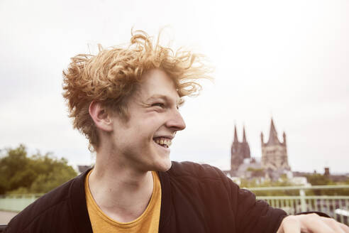 Porträt eines lachenden jungen Mannes mit wehendem Haar, Köln, Deutschland - FMKF06225