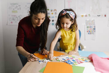 Mother and daughter doing crafts at home - EGAF00135