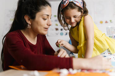 Mother and daughter doing crafts at home - EGAF00138