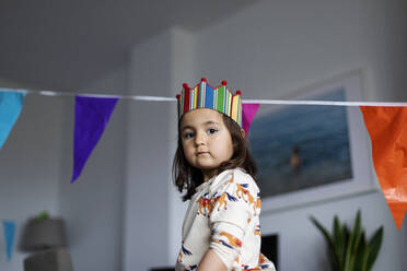 Porträt eines ernsten kleinen Mädchens, das seinen Geburtstag zu Hause feiert - VABF03016