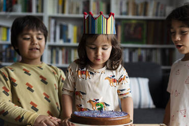 Porträt eines kleinen Mädchens, das seinen Geburtstag mit seinen älteren Brüdern zu Hause feiert - VABF03021