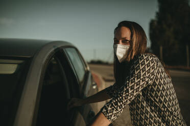 Mid adult woman with protective mask in car - DMGF00099