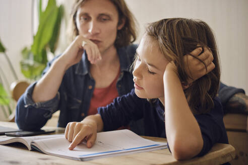 Vater hilft Sohn bei den Hausaufgaben zu Hause - PWF00133