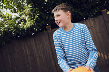 Glücklicher Junge spielt Basketball im Garten - PWF00140