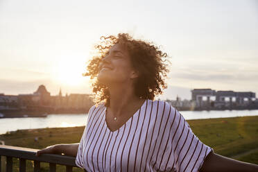 Portrait of smiling woman in the evening light - MJFKF00359