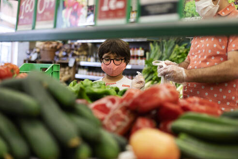 Father and son wearing masks in supermarket - VABF03037