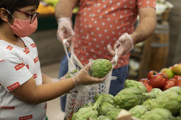 Son with mask and gloves taking artichoke - VABF03038