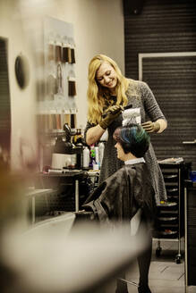 Woman getting highlights at hairdresser - JATF01197