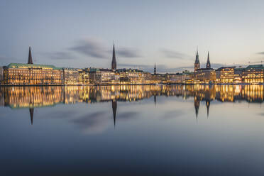 Germany, Hamburg, Buildings reflecting in Inner Alster Lake at dusk - KEBF01529