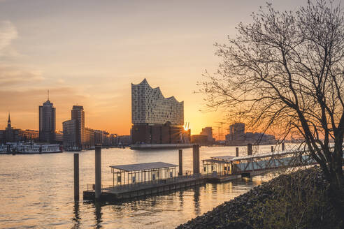 Deutschland, Hamburg, Leerer Hafen am Elbufer bei Sonnenaufgang mit Elbphilharmonie im Hintergrund - KEBF01533