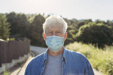Senior man with protective mask outdoors - AFVF06596
