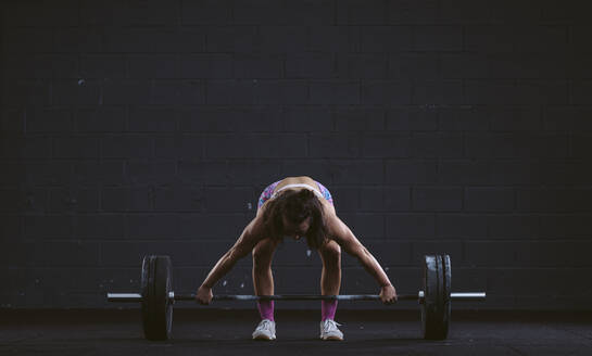 Young woman practicing barbell squat at gym - SNF00278