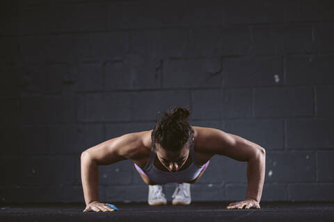 Woman practicing push-up exercise at gym stock photo