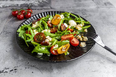 Plate of low carb vegetarian salad with arugula, tomatoes, nuts and Mozzarella cheese - SARF04597