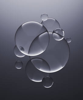 Three dimensional render of transparent glass spheres against gray background - DRBF00171