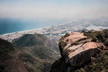Luftaufnahme von zwei Menschen saß auf Pedra Bonita Rock mit Barra Da Tijuca in der Ferne, Rio De Janeiro, Brasilien - AAEF08903