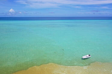 Luftaufnahme eines kleinen Bootes, das in der Lagune des Farquhar-Atolls auf den Seychellen in Ufernähe vor Anker liegt - AAEF08954