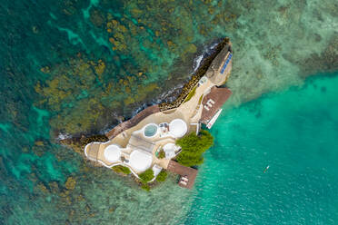 Luftaufnahme eines Hauses auf der Insel Pelicano, umgeben von türkisfarbenem Wasser im Karibischen Meer, Kolumbien - AAEF09010