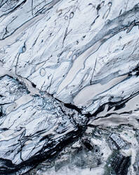Luftaufnahme des Gletschers Solheimajokull und Nahaufnahme der Muster, die durch schwarze Vulkanasche zwischen dem Eis entstehen, Südisland. - AAEF09036