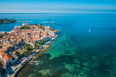 Luftaufnahme von Häusern umgeben von türkisfarbenem Wasser an einem sonnigen Tag in Porec, Kroatien - AAEF09071