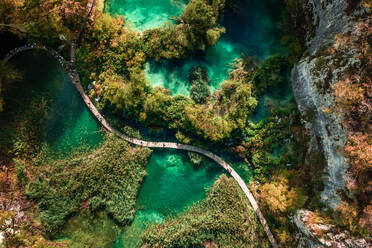 Luftaufnahme eines von türkisfarbenem Wasser umgebenen Holzstegs in Lower Lakes, Korana, Kroatien - AAEF09072