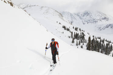Woman on backcountry ski tour, Mayflower Gulch, Colorado - CAVF84543