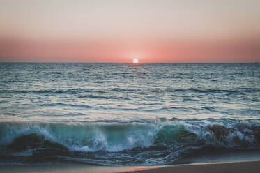 Sonnenuntergang am rosafarbenen Himmel über dem Pazifischen Ozean, während die Wellen in Mexiko schlagen - CAVF84572