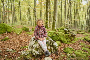 Fröhliches kleines Kind in warmer Kleidung, das in die Kamera schaut und lächelt, während s - CAVF84623