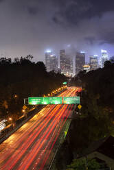 Car Streak By Bridges and Freeway on Foggy Night in Downtown LA - CAVF84775